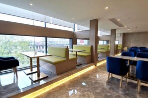 A modern hotel lobby with seating areas, a reception desk, and large windows offering a view of the city. - Wangfu Hotel (Fuzhou Donghua University of Technology) (Fuzhou)