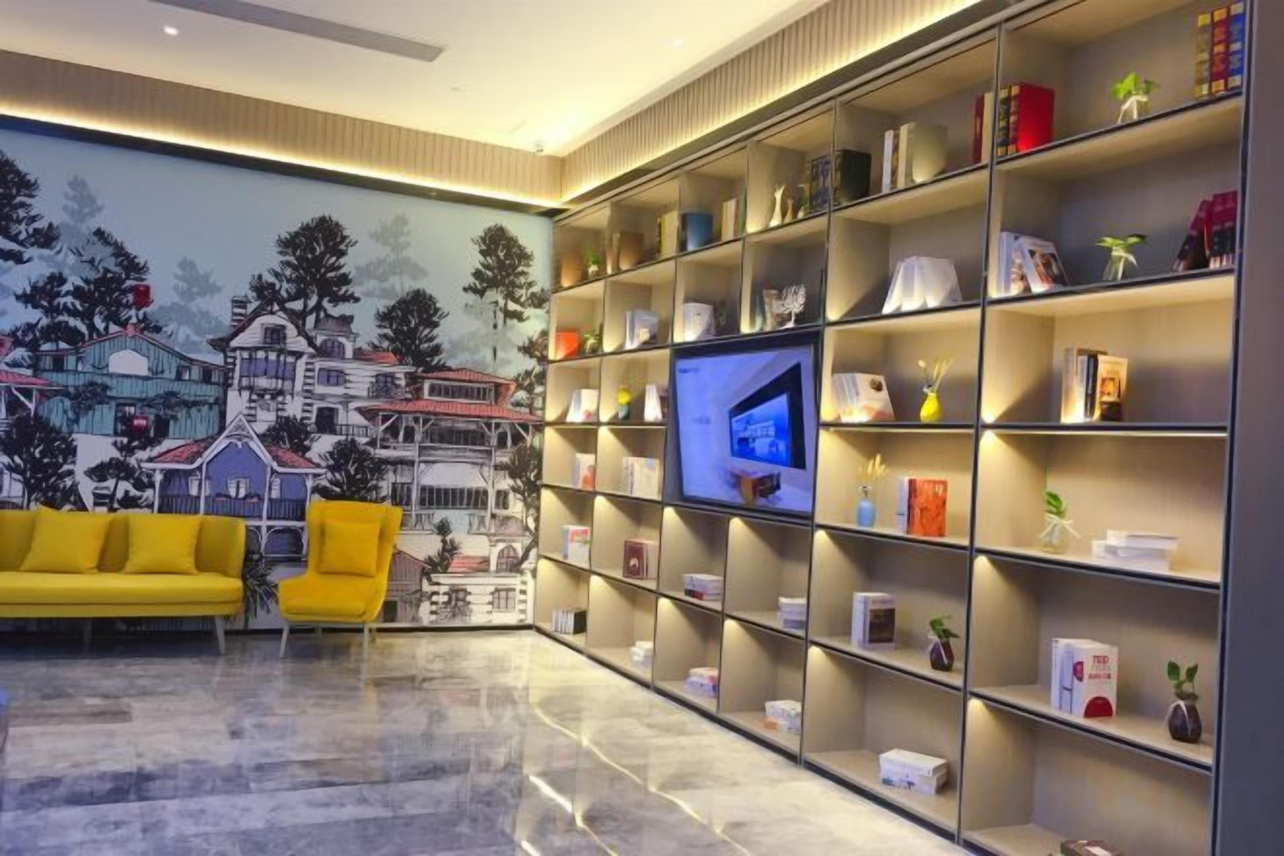 Un salon moderne avec un canapé jaune, une grande bibliothèque et un téléviseur à écran plat.