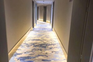 A corridor with a patterned floor leading to a door. - Wangfu Hotel (Fuzhou Donghua University of Technology) (Fuzhou)
