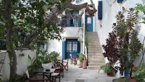 Une cour avec des sièges en plein air, un escalier et des plantes en pot.