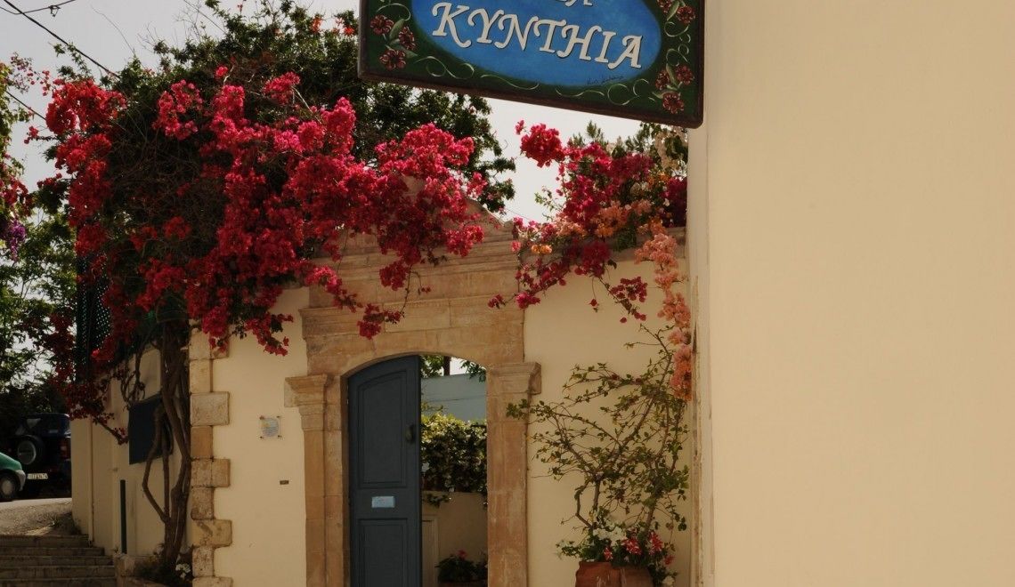 A building entrance with a sign reading "KYNTHIA" and a stone archway.