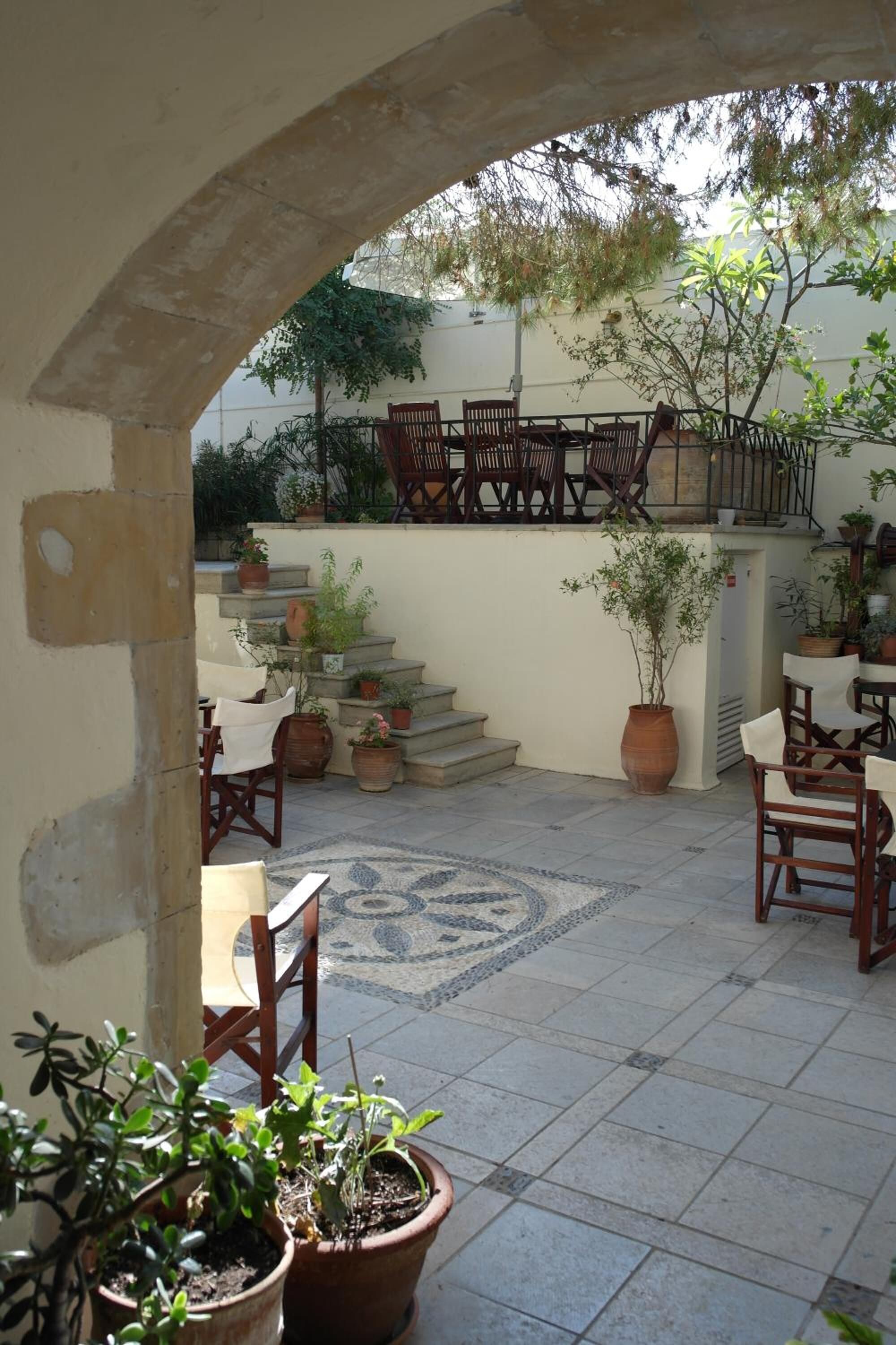 Une terrasse extérieure avec des marches en pierre, des meubles en bois et des plantes en pot.