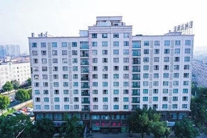 A multi-story hotel building with a symmetrical facade, large windows, and a flat roof.