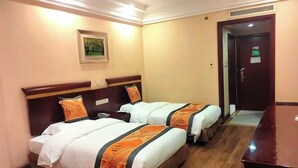 A hotel room with two beds, a wooden floor, a painting on the wall, and a door with a sign. - Hengdian World Studios Xinghe Grand Hotel (Ming and Qing Palace Scenic Area) (Dongyang)