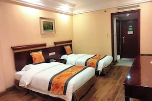 A hotel room with two beds, a wooden floor, a painting on the wall, and a door with a sign. - Hengdian World Studios Xinghe Grand Hotel (Ming and Qing Palace Scenic Area) (Dongyang)