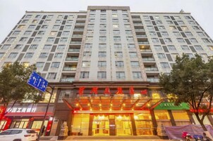 Un hotel de varios pisos con una entrada destacada, un cartel visible y una vista despejada del entorno.