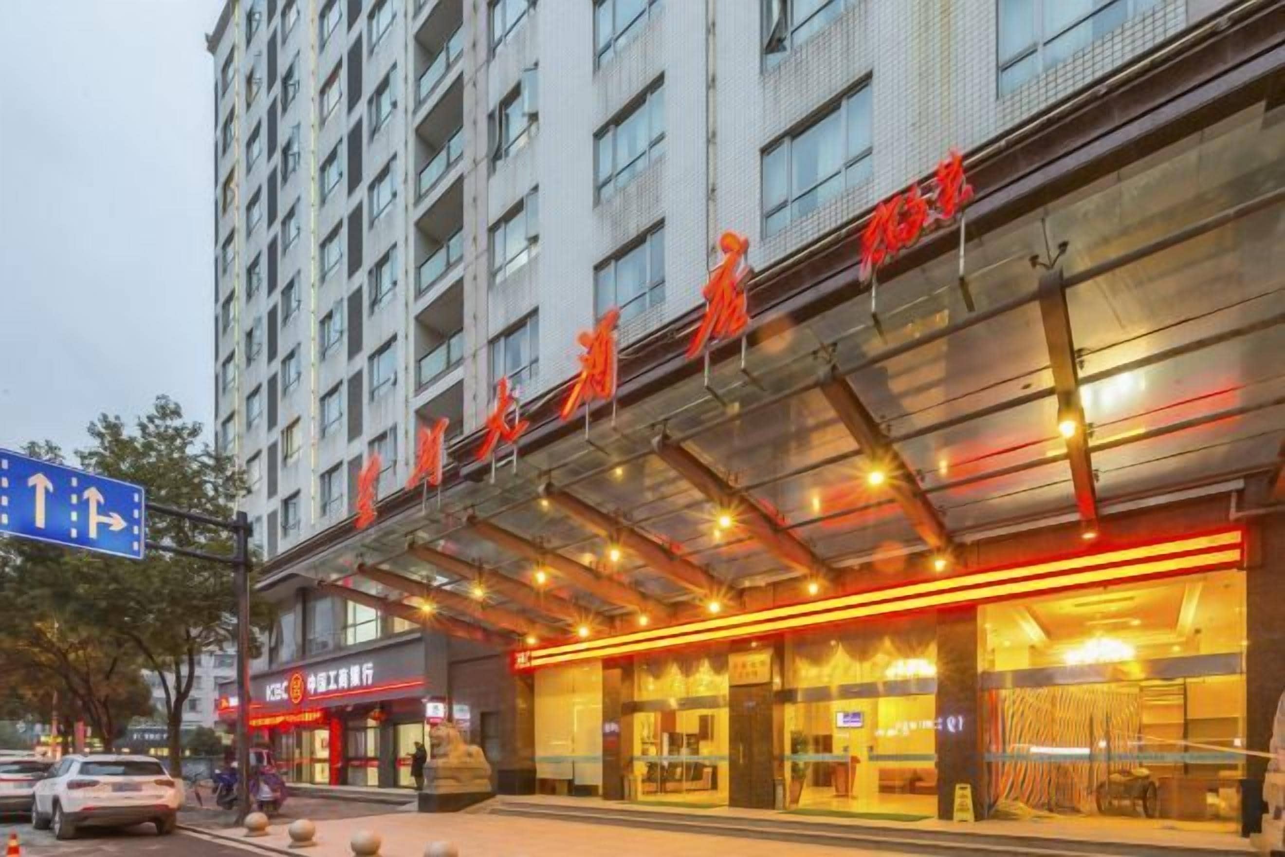 A hotel with a modern facade, a covered entrance, and a sign indicating a restaurant.