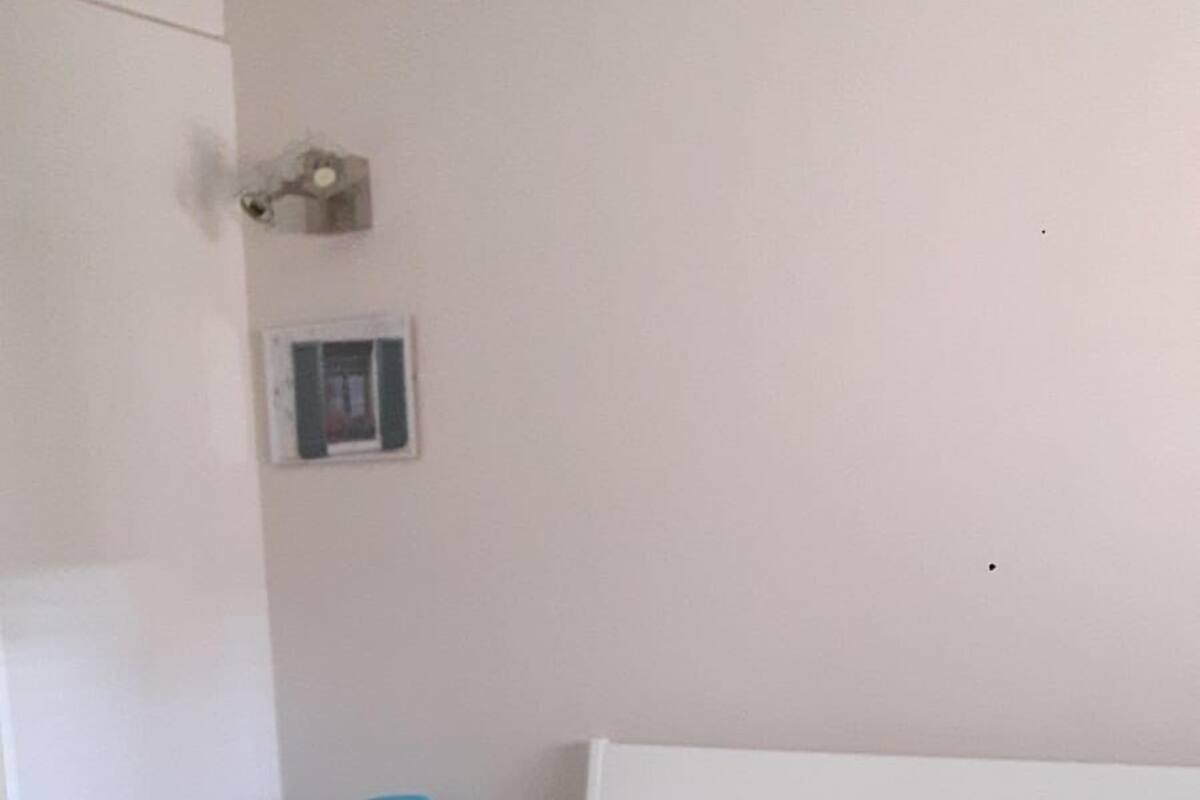 Une chambre d’hôtel avec un lit, une table de chevet, une lampe et une fenêtre.