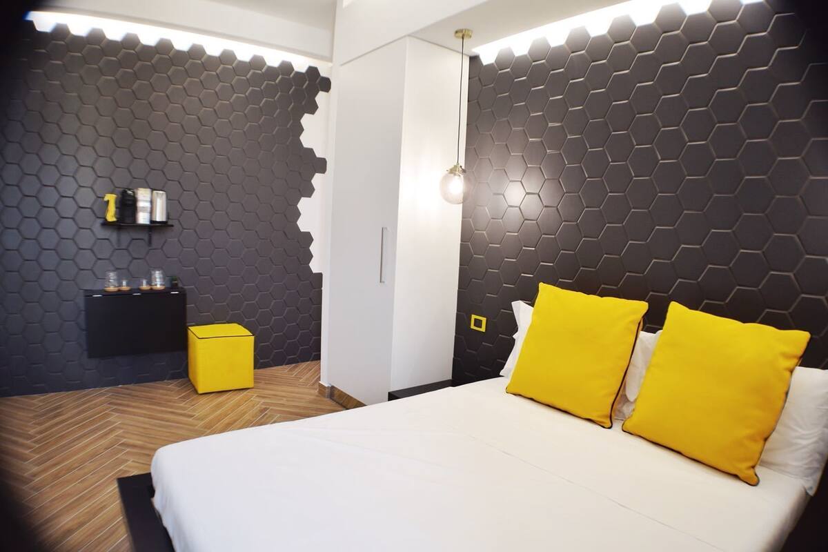 Une chambre à coucher moderne avec un grand lit, une petite table de chevet et une armoire.