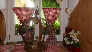 A rustic interior with a wooden table, checkered cloths, and decorative branches. - Landhaus Krone (Steinach)