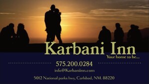 A Karbani Inn sign with silhouettes of people against a sunset. - Karbani Inn (Carlsbad)