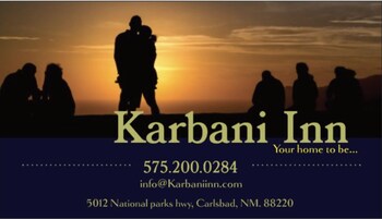 Letrero del Karbani Inn con siluetas de personas al atardecer.