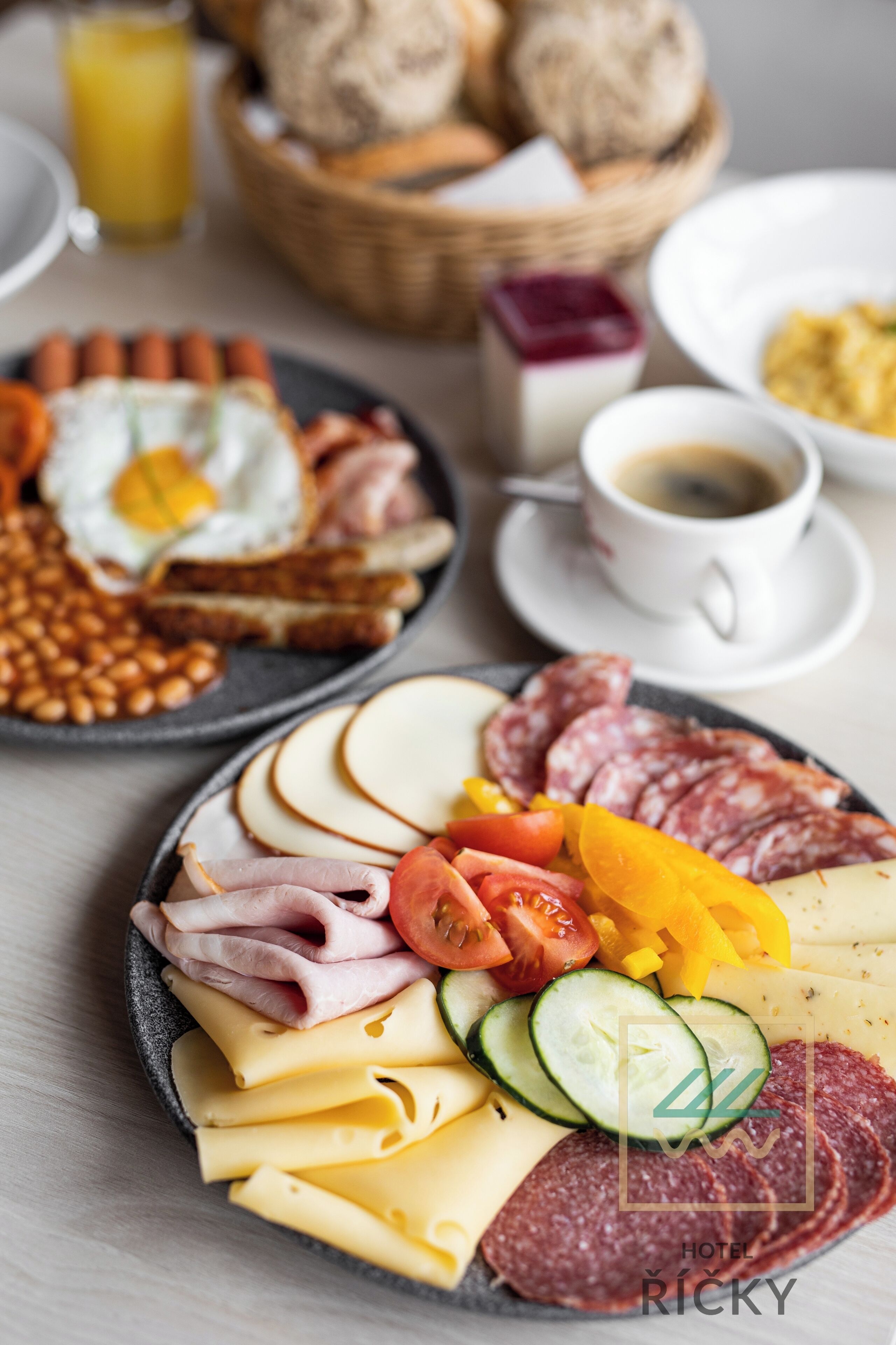 Una bandeja de desayuno con diferentes carnes, quesos y verduras.