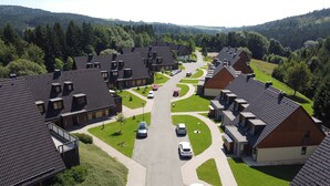 A residential area with multiple houses, a central road, and surrounding greenery. - Wellness hotel Říčky (Rícky v Orlických horách)