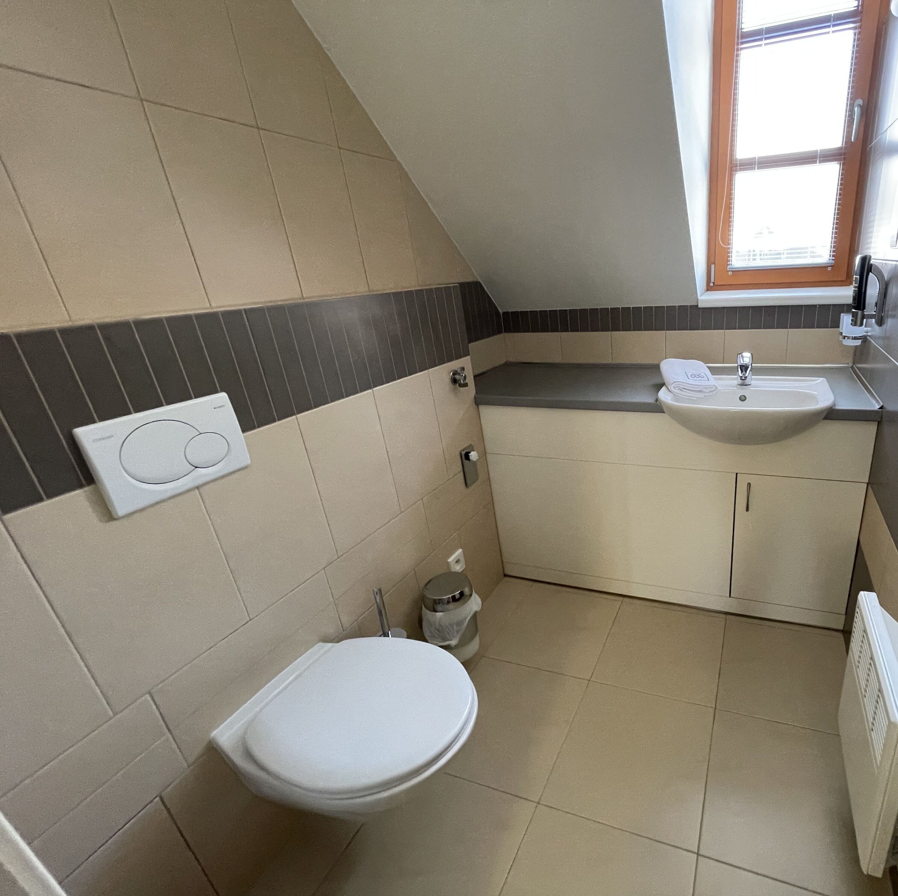 Un baño pequeño con inodoro, lavamanos y ventana.