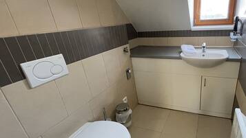 Un baño pequeño con inodoro, lavamanos y ventana.