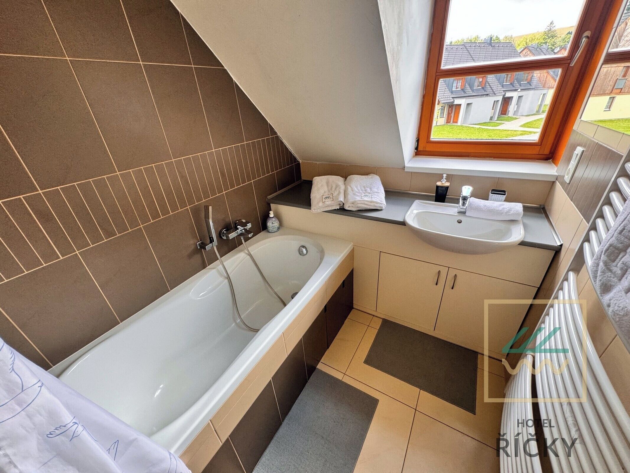 Un baño moderno con bañera, lavamanos y ventana.