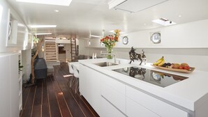 A modern kitchen with a central island, white cabinetry, and a built-in stove.