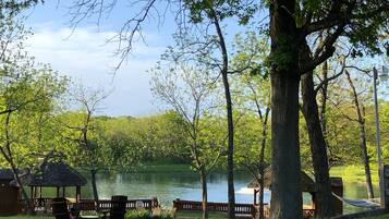 Una cabaña junto al lago con asientos exteriores y un pabellón.