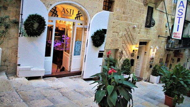 A building with a sign reading "ASTI BRASSERIE" and "GUEST HOUSE".