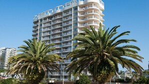 A multi-story hotel with balconies, surrounded by palm trees. - Beachcomber Beach, Coolangatta (Coolangatta)