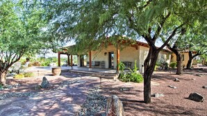 A courtyard with a pergola, stone pathway, and a building with a tiled roof. - Luxe Tucson Vineyard Home w/ Views & Fire Pit (Tucson)