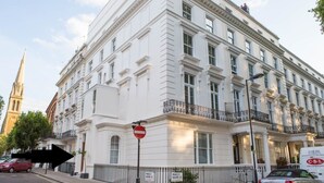 Ein weißes Gebäude mit Balkon, einem Verbotsschild und einem Schild mit der Aufschrift 'Prince's Square'.