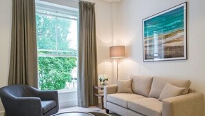 Ein Wohnzimmer mit einer Couch, einem Sessel und einem runden Couchtisch.
