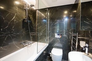 A modern bathroom with a glass-enclosed shower, a white toilet, and a white sink. - London Villa - 20 Princes Square (London)