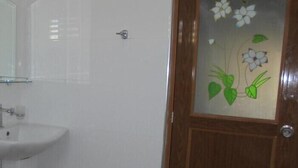 A bathroom with a white sink, a wooden door with a floral glass panel, and a mirror above the sink. - Spring holiday (Mirissa)