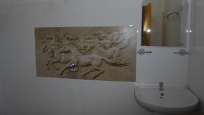 A bathroom with a wall-mounted sink, a mirror, and a decorative relief of horses. - Spring holiday (Mirissa)