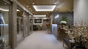 A modern hotel lobby with a wooden ceiling, a reception desk, and a seating area. - Whistler Lodge Apartment T3 Cabin B07 (Courchevel)