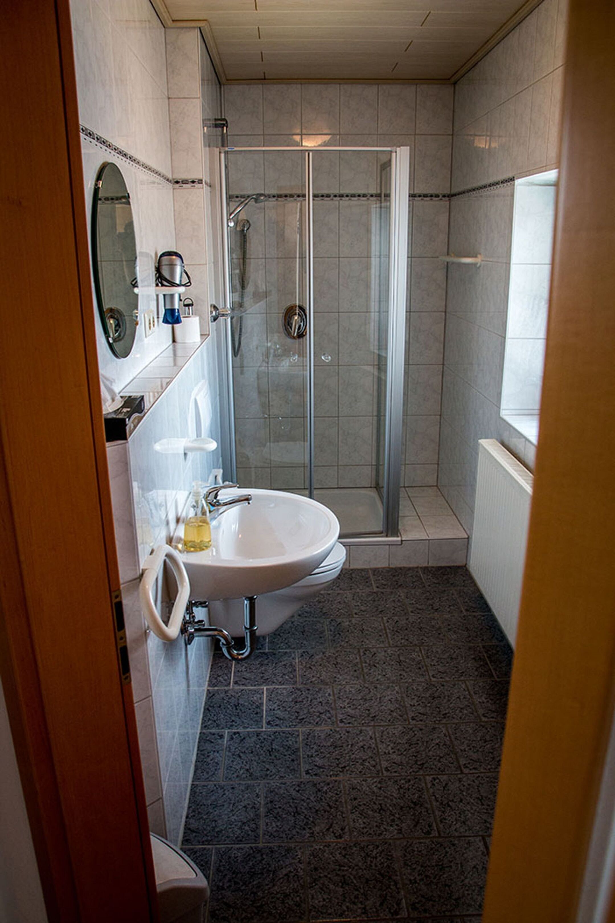 Un baño con ducha, lavamanos e inodoro.