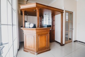 A spacious room with a large wooden cabinet, a glass door, and a tiled floor. - RedDoorz @ Pandu Raya Bogor (Bogor)