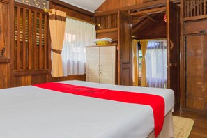 Een houten kamer met een bed, een kledingkast en een raam met gordijnen.