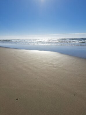 Una playa con cielo despejado y mar tranquilo.