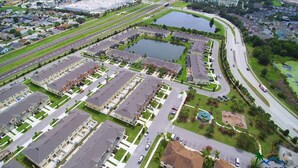An aerial view of a residential area with multiple apartment buildings, roads, and a large body of water.