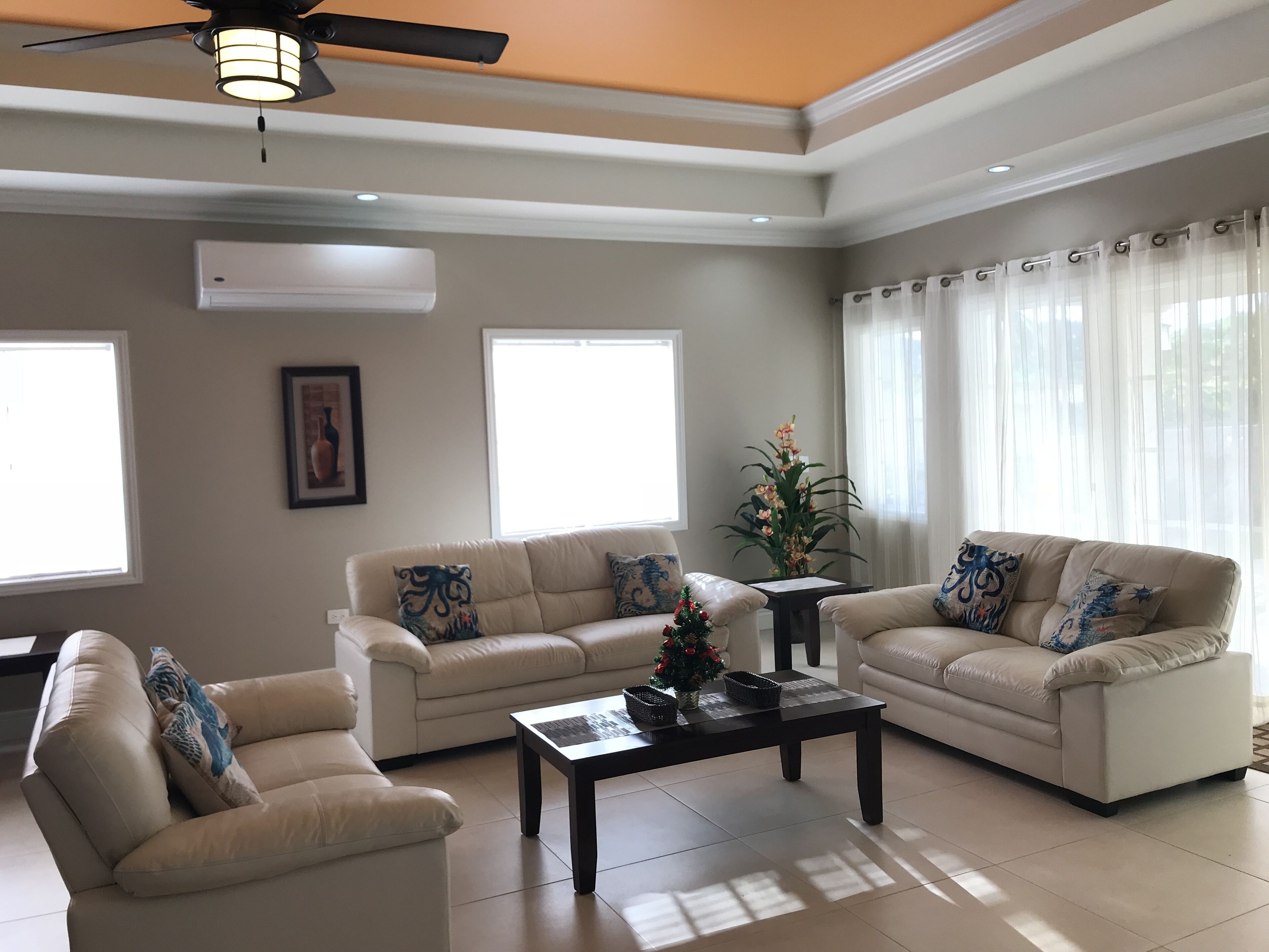 Sala de estar com dois sofás, uma mesa de centro e um ventilador de teto.