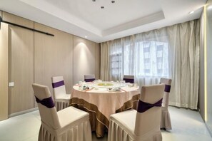 A conference room with a round table, six chairs, and a tablecloth. - Huangdu International Hotel (Jiange)
