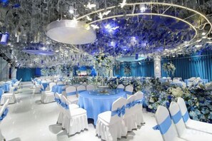 A banquet hall with round tables, white chairs, and blue accents. - Huangdu International Hotel (Jiange)