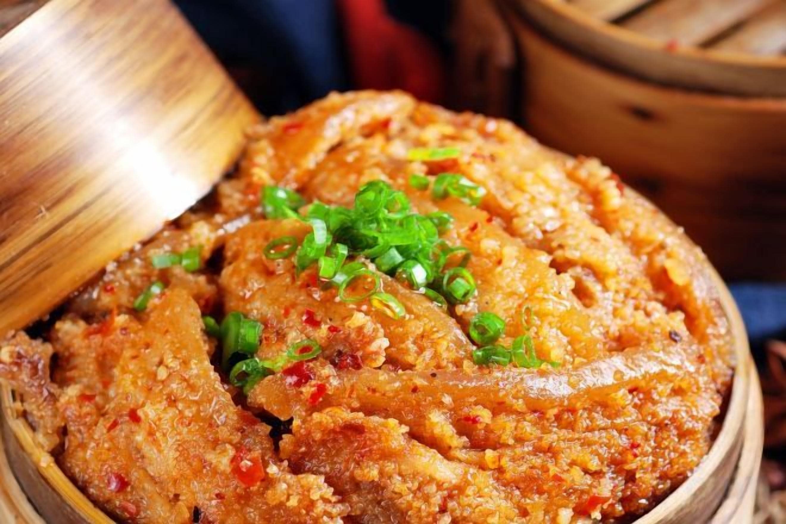 A dish garnished with green onions, served in a wooden bowl.