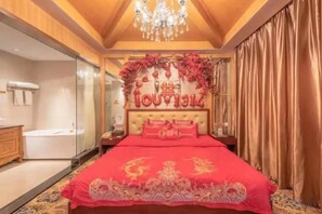 Une chambre à coucher avec un grand lit, un lustre et un mur décoratif sur lequel est inscrit le mot « ARGENT ».