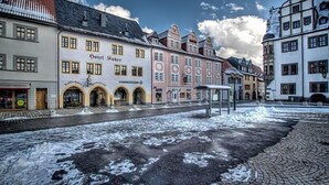 Ein historisches Gebäude mit einem Schild, auf dem 'Hotel Sinker' und 'COMMERZBANK' im Erdgeschoss stehen.
