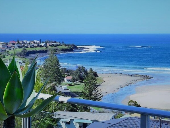 Vista costeira com praia, oceano e área residencial.