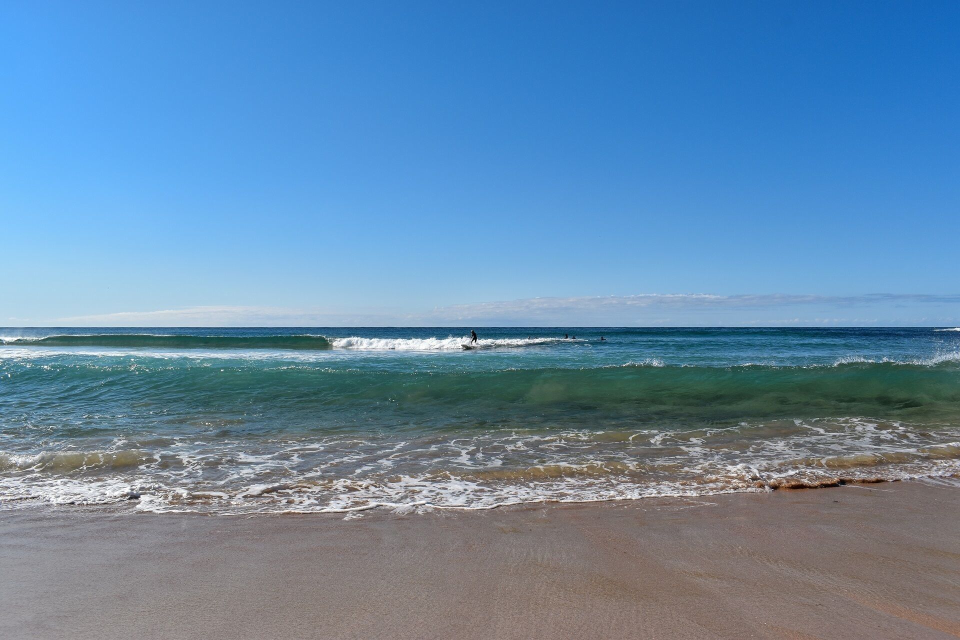 A beach with clear skies and waves.