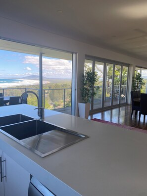 A modern kitchen with a large window overlooking a scenic landscape.