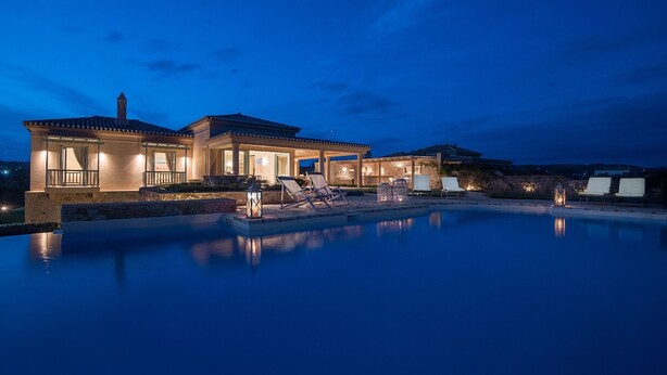 A large house with a swimming pool, multiple lounge chairs, and a covered patio area. - Villa Gold in Petrothalassa (Porto Cheli)
