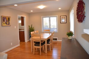 Enjoy meals in this cozy dining area with a table, chairs, and a potted plant.