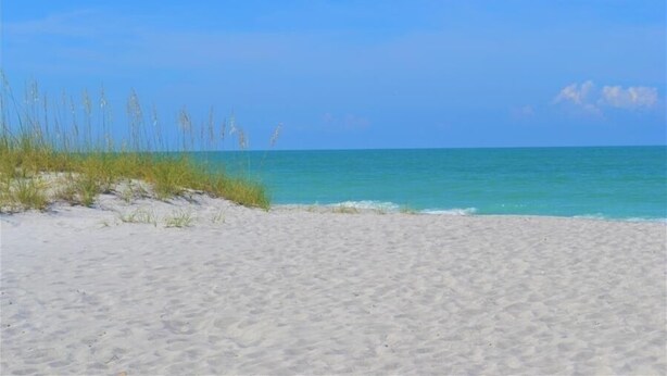 A beach with clear blue water and white sand. - Beachcomber unit 303 (Longboat Key)
