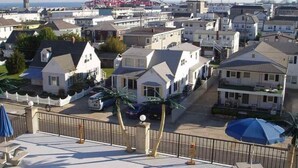 A residential area with houses, a parking lot, and a distant roller coaster. - NEW! Beach Chic-Pool-triple bunks-Slps 7-beach chairs & cart-elev-off BW (North Wildwood)